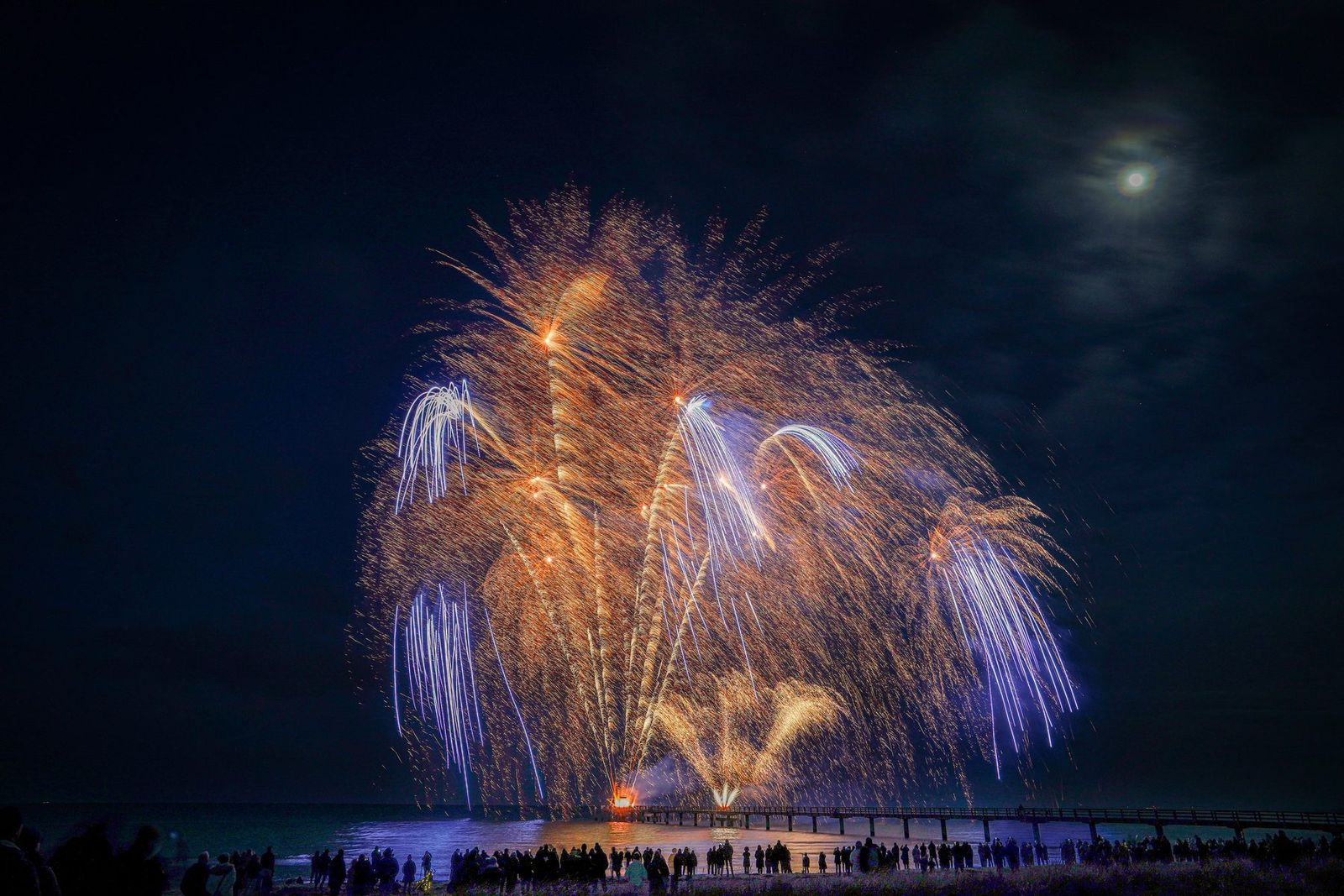 Feuerwerk mit Mond über der Seebrücke