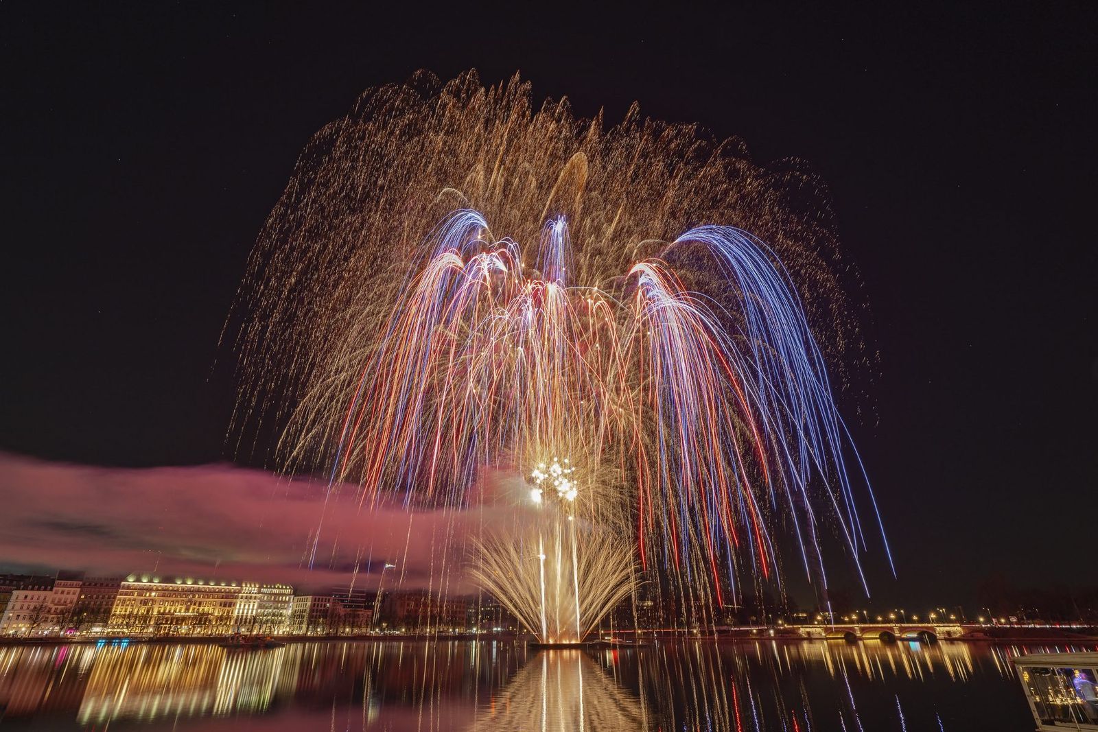 Aufgefächertes Feuerwerk über dem Wasser