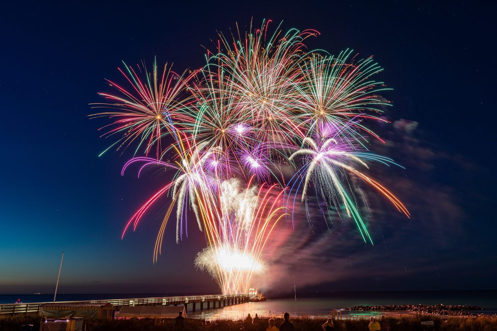 Buntes Feuerwerk über der Seebrücke zur blauen Stunde