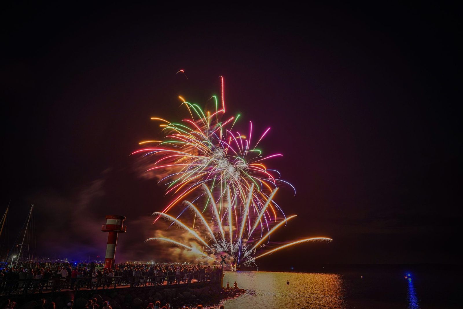 Feuerwerk über dem Wasser vor Publikum bei einem Stadtfest